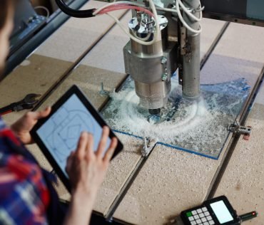 Engineer with touchpad and lathe machine